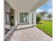 Covered patio with brick flooring, offering a seamless transition to the lush backyard and living spaces at 10013 Brocksport Cir, Gotha, FL 34734