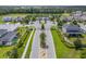 Scenic aerial view of Lakeside community entrance with landscaped median, manicured lawns and neighborhood pool at 1062 Lakeside Estates Dr, Apopka, FL 32703