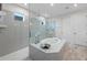 Elegant bathroom showcasing a tiled shower with glass enclosure, a soaking tub, and modern fixtures and finishes at 1062 Lakeside Estates Dr, Apopka, FL 32703
