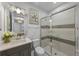 Chic bathroom with a single vanity, granite countertop, framed mirror, and glass-enclosed shower featuring a geometric pattern at 1062 Lakeside Estates Dr, Apopka, FL 32703