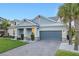Inviting single-story home with a well-manicured lawn, palm trees, and a brick-paved driveway, creating a warm atmosphere at 1062 Lakeside Estates Dr, Apopka, FL 32703