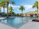 Community pool with palm trees and lounge chairs with a covered picnic area at 1062 Lakeside Estates Dr, Apopka, FL 32703