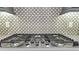 A gas stovetop is designed with stylish backsplash, offering functionality and modern style at 1062 Lakeside Estates Dr, Apopka, FL 32703