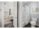 Bright bathroom featuring a shower with floral curtain and a white toilet with matching trim and a bedroom in the background at 10664 Emerald Chase Dr, Orlando, FL 32836