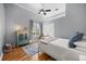 Bright bedroom featuring hardwood floors, ceiling fan, window and a cabinet at 10664 Emerald Chase Dr, Orlando, FL 32836