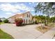 Spacious home featuring a long driveway, mature landscaping, and a classic red tile roof at 10664 Emerald Chase Dr, Orlando, FL 32836