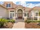 Charming home with a brick walkway leading to a covered arched entryway and double doors at 10664 Emerald Chase Dr, Orlando, FL 32836