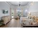 Serene main bedroom featuring a tray ceiling, ceiling fan, a door to the outside, and ample natural light at 10664 Emerald Chase Dr, Orlando, FL 32836