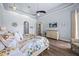 Spacious bedroom featuring a tray ceiling, ceiling fan, and a large dresser with a wall-mounted television at 10664 Emerald Chase Dr, Orlando, FL 32836