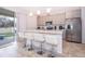 Modern kitchen with stainless steel appliances, light-colored cabinets and a marble island at 1092 Sugarwood St, Davenport, FL 33837