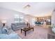 Open living room features plush seating, modern light fixture, and dining area with stainless steel appliances at 1092 Sugarwood St, Davenport, FL 33837