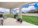 Covered patio with exercise equipment overlooks large backyard with privacy fence and space for entertaining at 1092 Sugarwood St, Davenport, FL 33837