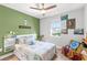 Bright bedroom with green accent wall, decorative art, and a cozy reading chair at 12067 Eastmoor Dr, Winter Garden, FL 34787