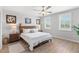 Cozy bedroom featuring a wood bed frame, wood flooring, plantation shutters, and decorative artwork at 12067 Eastmoor Dr, Winter Garden, FL 34787