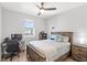 Comfortable bedroom with wood bed frame, ceiling fan, and adjacent desk at 12067 Eastmoor Dr, Winter Garden, FL 34787
