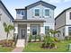 Charming two-story home with gray siding, teal shutters, and beautifully landscaped front yard at 12067 Eastmoor Dr, Winter Garden, FL 34787
