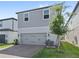 Two-story home with a gray garage door, brick paver driveway and green lawn at 12067 Eastmoor Dr, Winter Garden, FL 34787