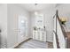 Clean and bright foyer with white cabinet, decorative rug, and stairway with white railing and newel post at 12067 Eastmoor Dr, Winter Garden, FL 34787