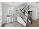 Bright foyer with wood-look floors, decorative rug, stairway with white railing and decorative cabinet at 12067 Eastmoor Dr, Winter Garden, FL 34787