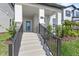 Inviting home entrance with well-kept concrete steps, a sleek black railing, and a charming glass-paneled front door at 12067 Eastmoor Dr, Winter Garden, FL 34787