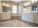 Stylish bathroom with double vanities, white cabinetry and tiled floors at 12334 Upper Harden Ave, Orlando, FL 32827