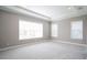 Spacious bedroom with plush carpeting, tray ceiling, and large windows at 12334 Upper Harden Ave, Orlando, FL 32827