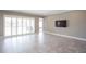 Open-concept living room with tile flooring, sliding glass doors and a wall-mounted television at 12334 Upper Harden Ave, Orlando, FL 32827