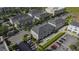 Aerial view showcasing the exterior of a row of modern townhomes with private garages and well-manicured landscaping at 12955 Cats Claw Ln, Orlando, FL 32828