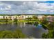 An aerial view of a community featuring colorful buildings surrounding a peaceful lake with a fountain at 12955 Cats Claw Ln, Orlando, FL 32828