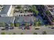 Aerial view of townhome surrounded by parking, palm trees, and nearby commercial development at 12955 Cats Claw Ln, Orlando, FL 32828