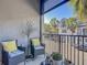 Relaxing balcony features comfortable seating and views of the community and palm trees at 12955 Cats Claw Ln, Orlando, FL 32828