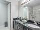 Bathroom with a double sink vanity with black cabinets, and a glass walk-in shower at 12955 Cats Claw Ln, Orlando, FL 32828