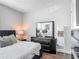 A comfortable bedroom featuring a dark wood dresser and accents with a plush bed and soft lighting at 12955 Cats Claw Ln, Orlando, FL 32828