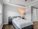 Cozy bedroom with a plush grey bed, wood floors, and bright natural light at 12955 Cats Claw Ln, Orlando, FL 32828