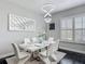 Bright dining area with modern chandelier, sleek white furniture, and dark wood floors at 12955 Cats Claw Ln, Orlando, FL 32828