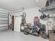 Spacious garage providing ample storage and parking, with motorcycle and bike at 12955 Cats Claw Ln, Orlando, FL 32828