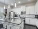 Modern kitchen with stainless steel appliances, white cabinetry, and an island with bar seating at 12955 Cats Claw Ln, Orlando, FL 32828
