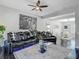 Spacious living area with comfortable seating, ceiling fan, and view of dining area at 12955 Cats Claw Ln, Orlando, FL 32828