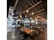 Restaurant interior with wooden tables, black chairs, rope and bulb lighting, and a serving area at 12955 Cats Claw Ln, Orlando, FL 32828