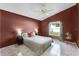 Comfortable bedroom with tile floors, ceiling fan, and natural light from the window at 13416 Greenpointe Dr, Orlando, FL 32824