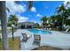 Community pool area featuring ample seating, swaying palm trees, and clear blue water, perfect for relaxation at 13416 Greenpointe Dr, Orlando, FL 32824