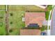 Aerial view of a home with a tile roof, solar panels, and a lush green lawn with manicured landscaping at 1415 Oak Marsh St, Davenport, FL 33837