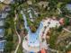 Aerial view of community lazy river and pool with orange canopies surrounded by trees and landscaping at 1415 Oak Marsh St, Davenport, FL 33837