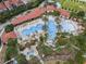 Aerial view of the community pool with slides and lounge areas surrounded by palm trees at 1415 Oak Marsh St, Davenport, FL 33837