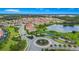 Aerial image of a circle and entry to a community surrounded by a pond, trees, and green space at 1415 Oak Marsh St, Davenport, FL 33837
