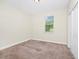 A bright bedroom featuring neutral walls, plush carpeting, and a window that provides plenty of natural light at 1415 Oak Marsh St, Davenport, FL 33837