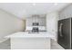 Bright kitchen features a large quartz countertop island and stainless steel refrigerator at 1415 Oak Marsh St, Davenport, FL 33837
