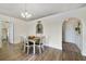 Inviting dining room with light-colored walls, laminate flooring, and an arched doorway to other living spaces at 14620 Old Forest Ct, Orlando, FL 32826