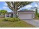 Charming home exterior featuring a 2-car garage, inviting front yard, and mature landscaping with a large shade tree at 14620 Old Forest Ct, Orlando, FL 32826