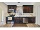 Modern kitchen with dark wood cabinets, stainless steel appliances, granite countertops, and stylish backsplash at 14620 Old Forest Ct, Orlando, FL 32826